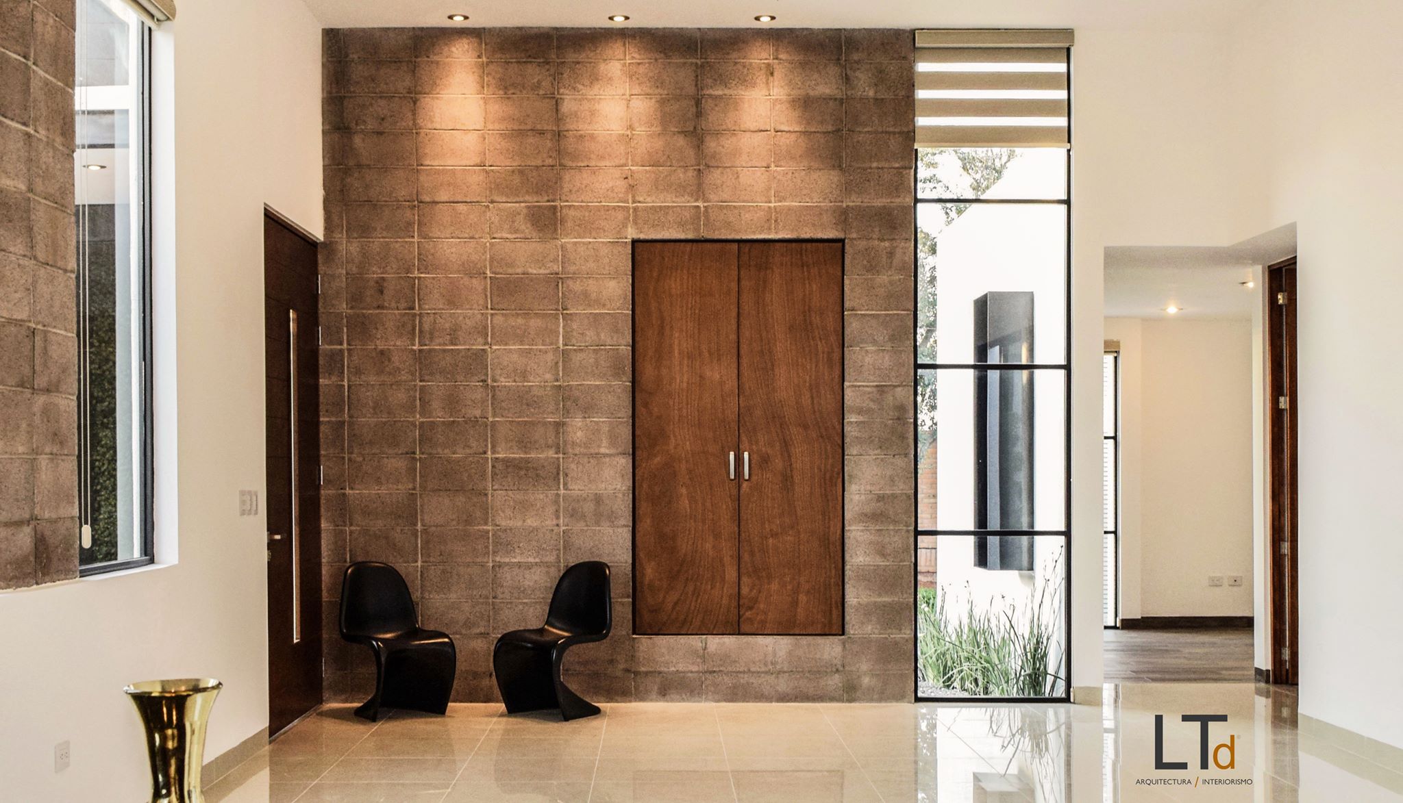 Vestíbulo con muro texturizado y mobiliario